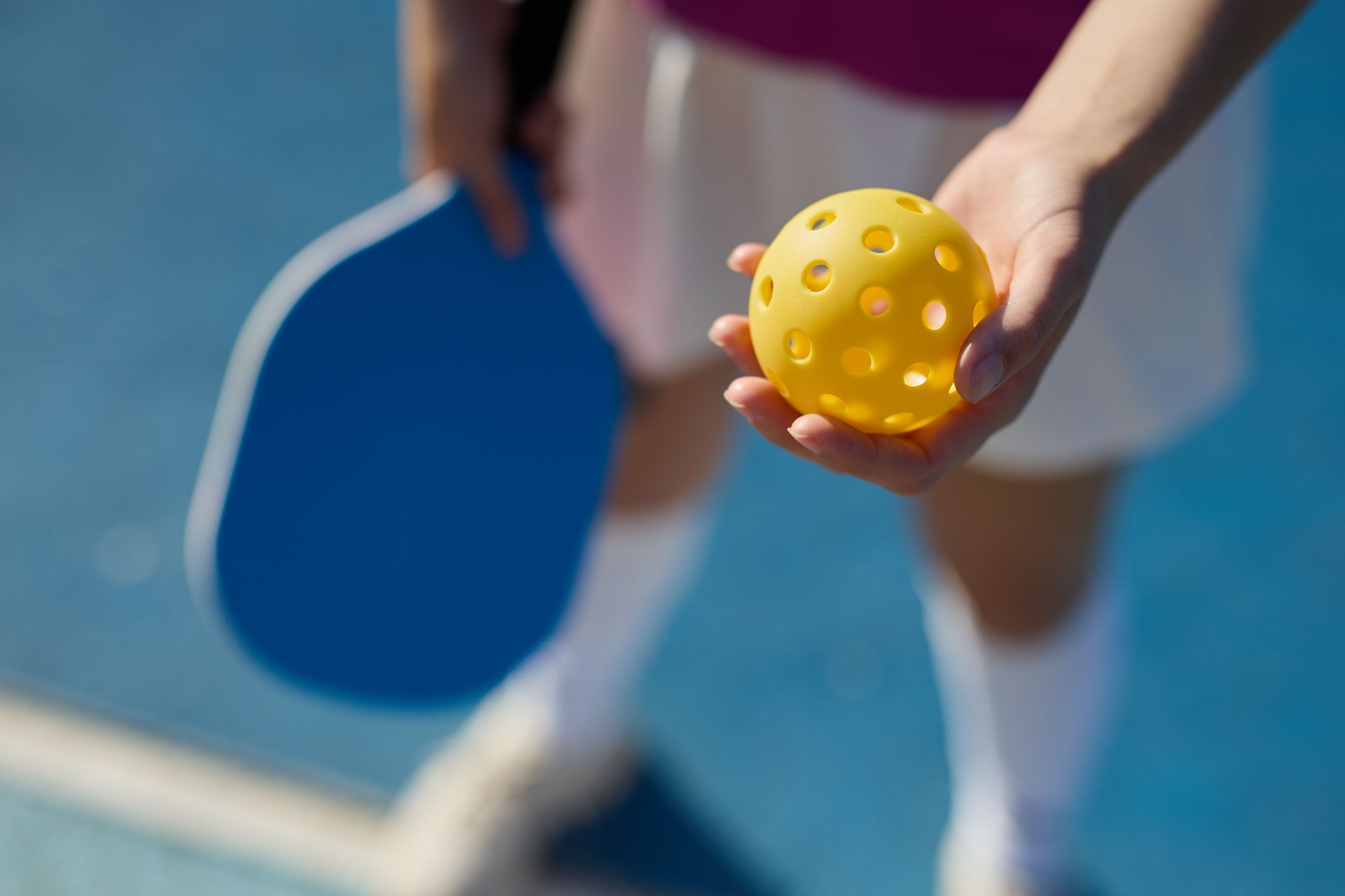 Pickle ball player serving a ball