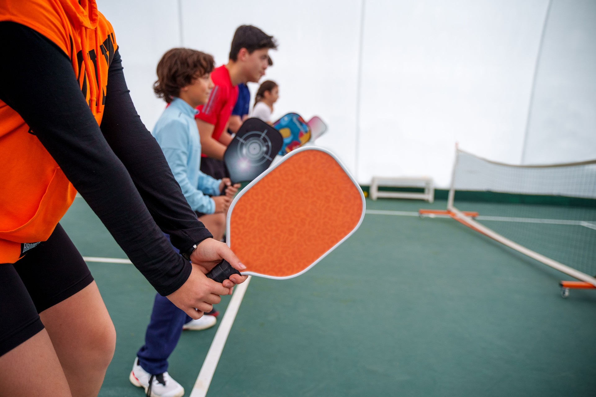 Group of Kids Playing Pickleball with a Coach Indoors