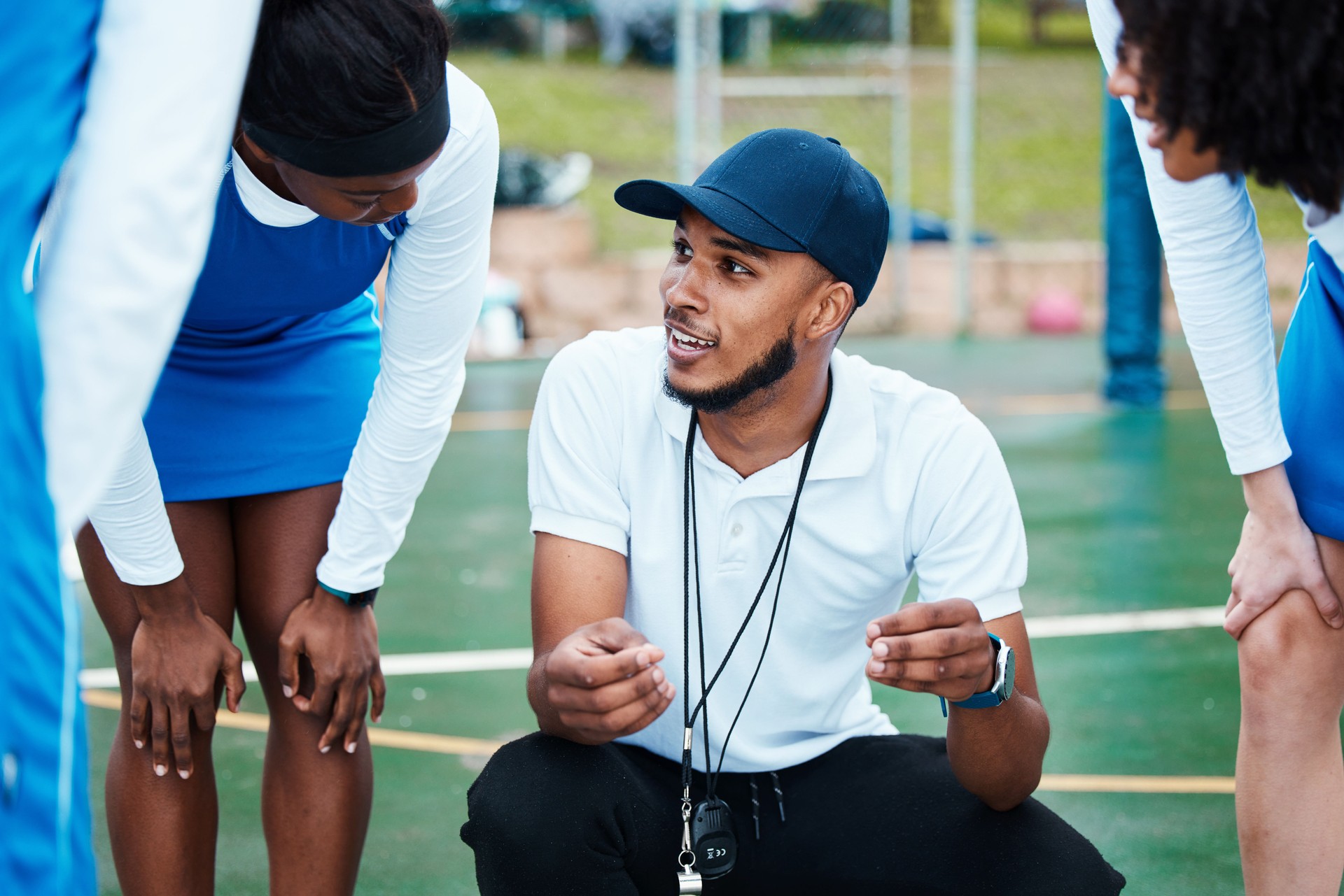 Coach, strategy and teamwork with sports people listening to tactics or instructions on a court. Fitness, team and planning with a black man talking to a group of girls during a competition